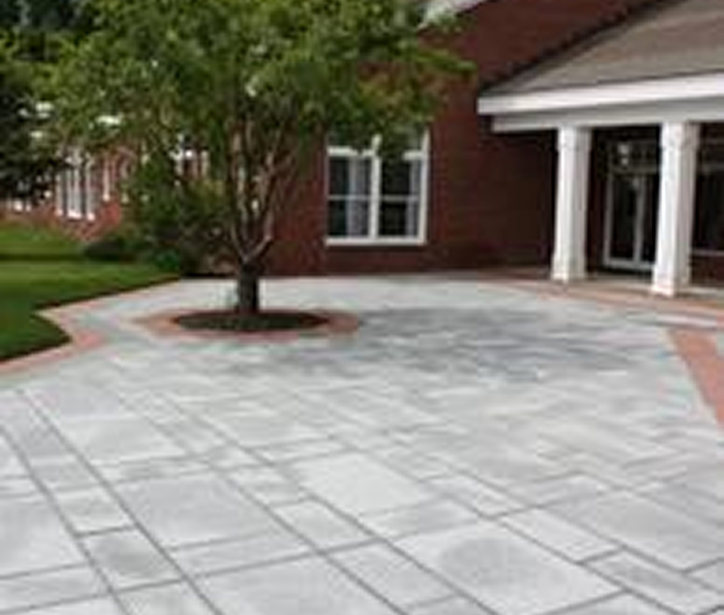 Brick building with tree and paved walkway.