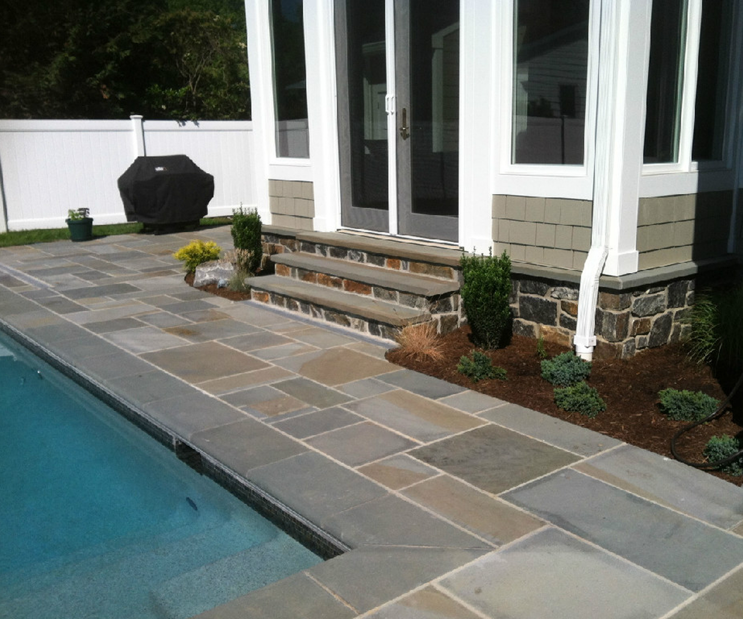 Stone patio beside swimming pool
