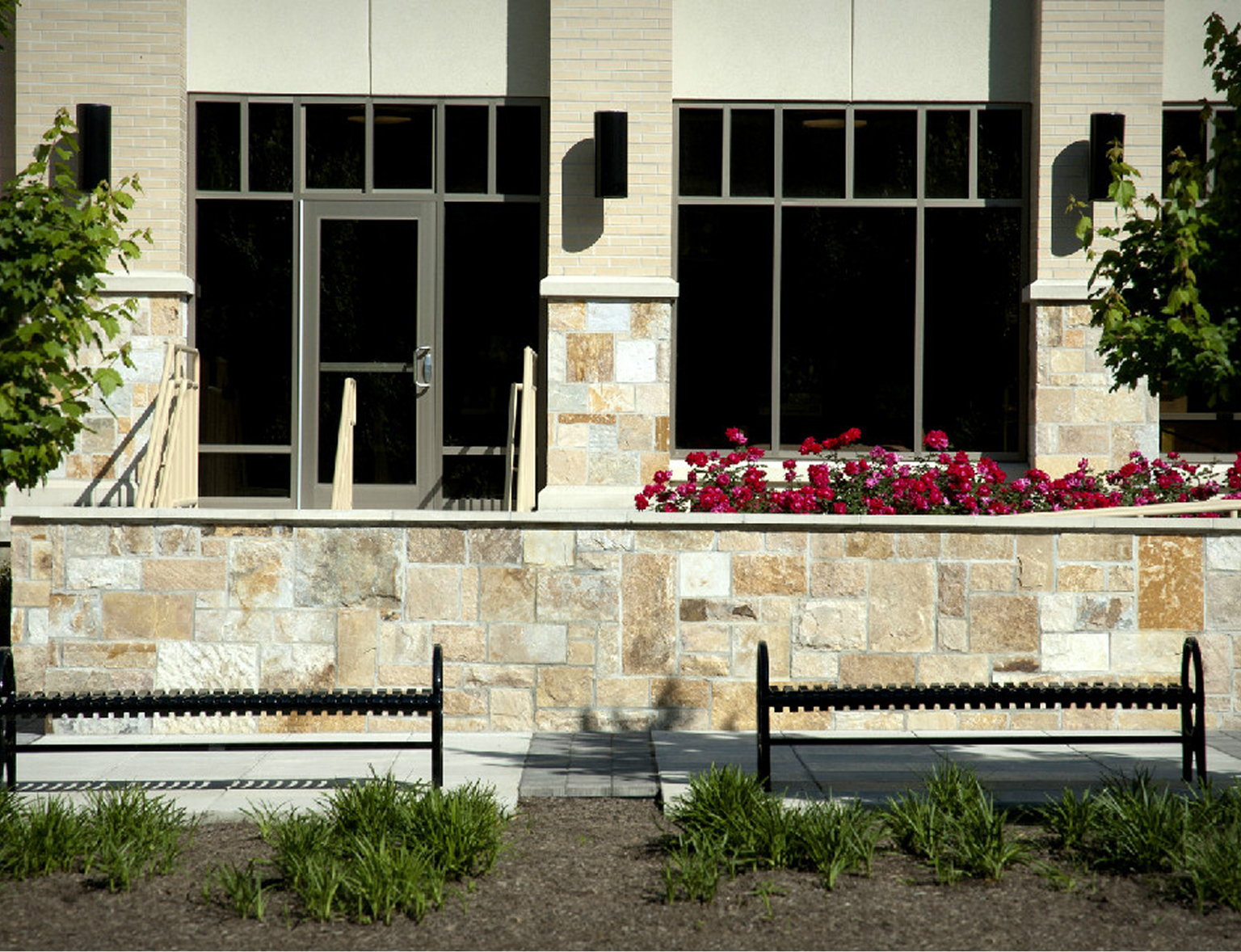 Building entrance with stone wall and benches