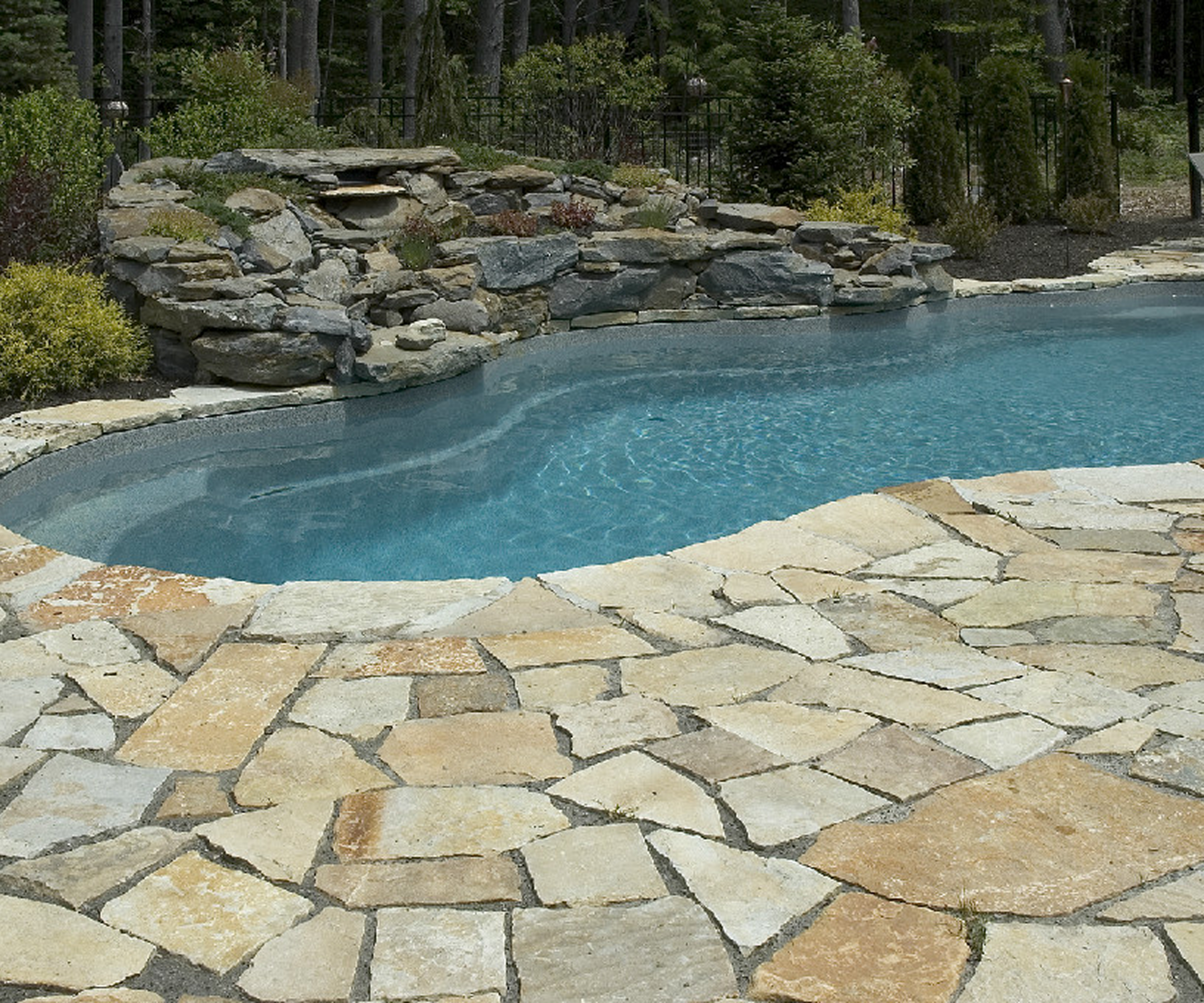 Stone-paved pool with waterfall feature