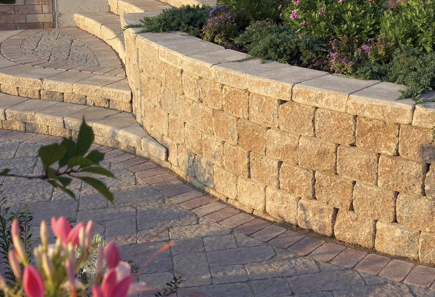 Stone retaining wall with pink flowers