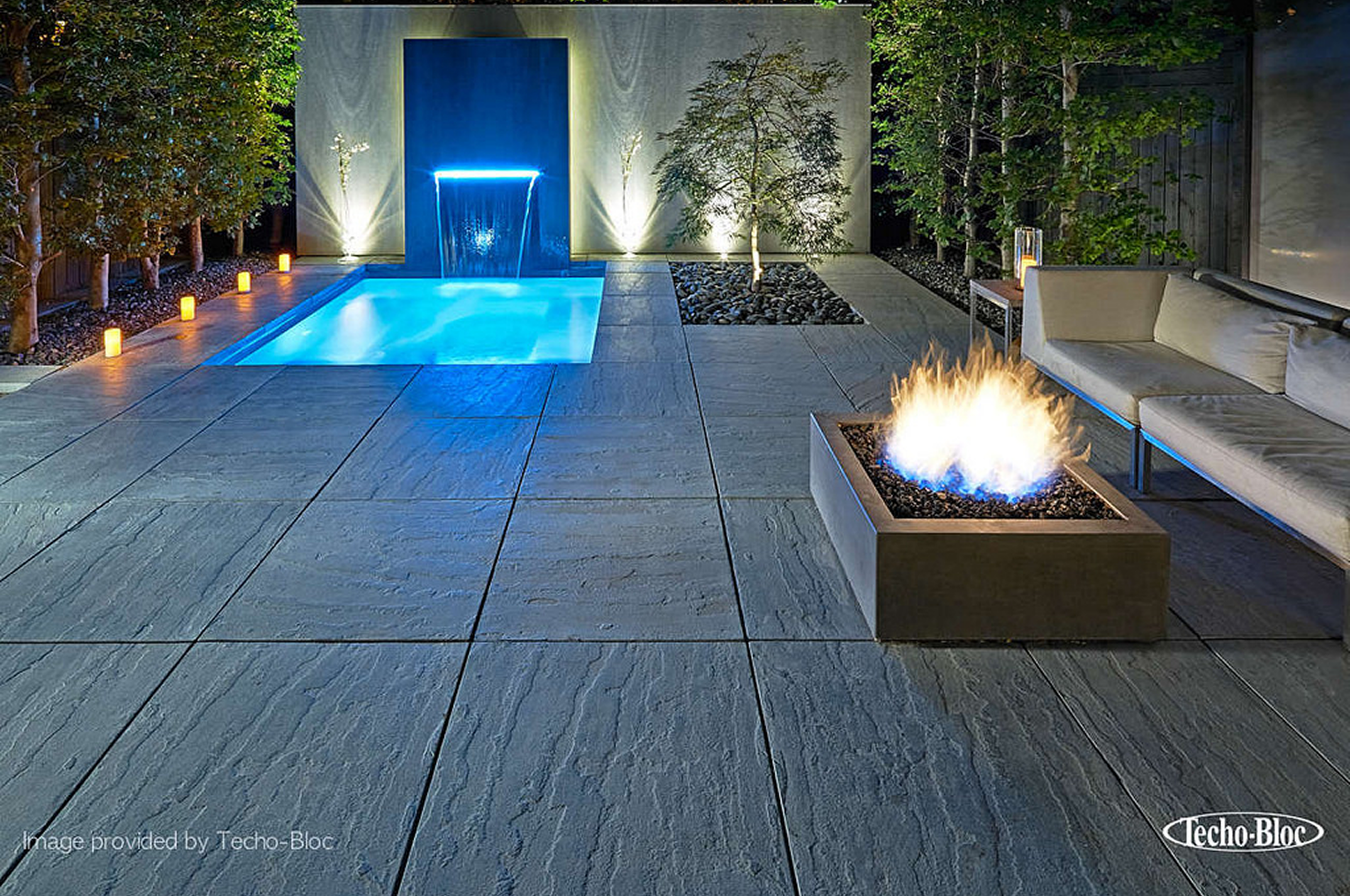 Sleek outdoor space with blue-lit pool.