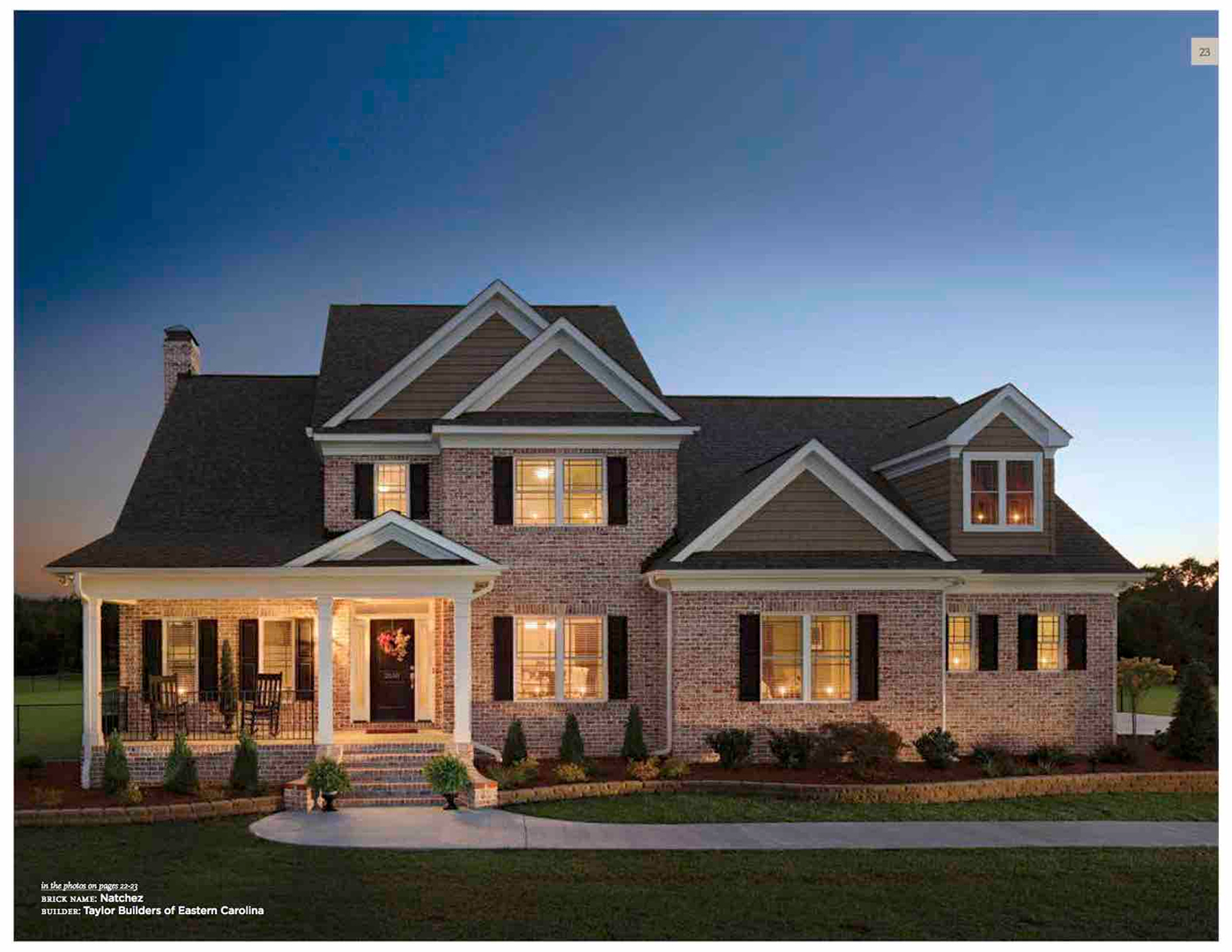 Brick house with warm lighting at dusk.