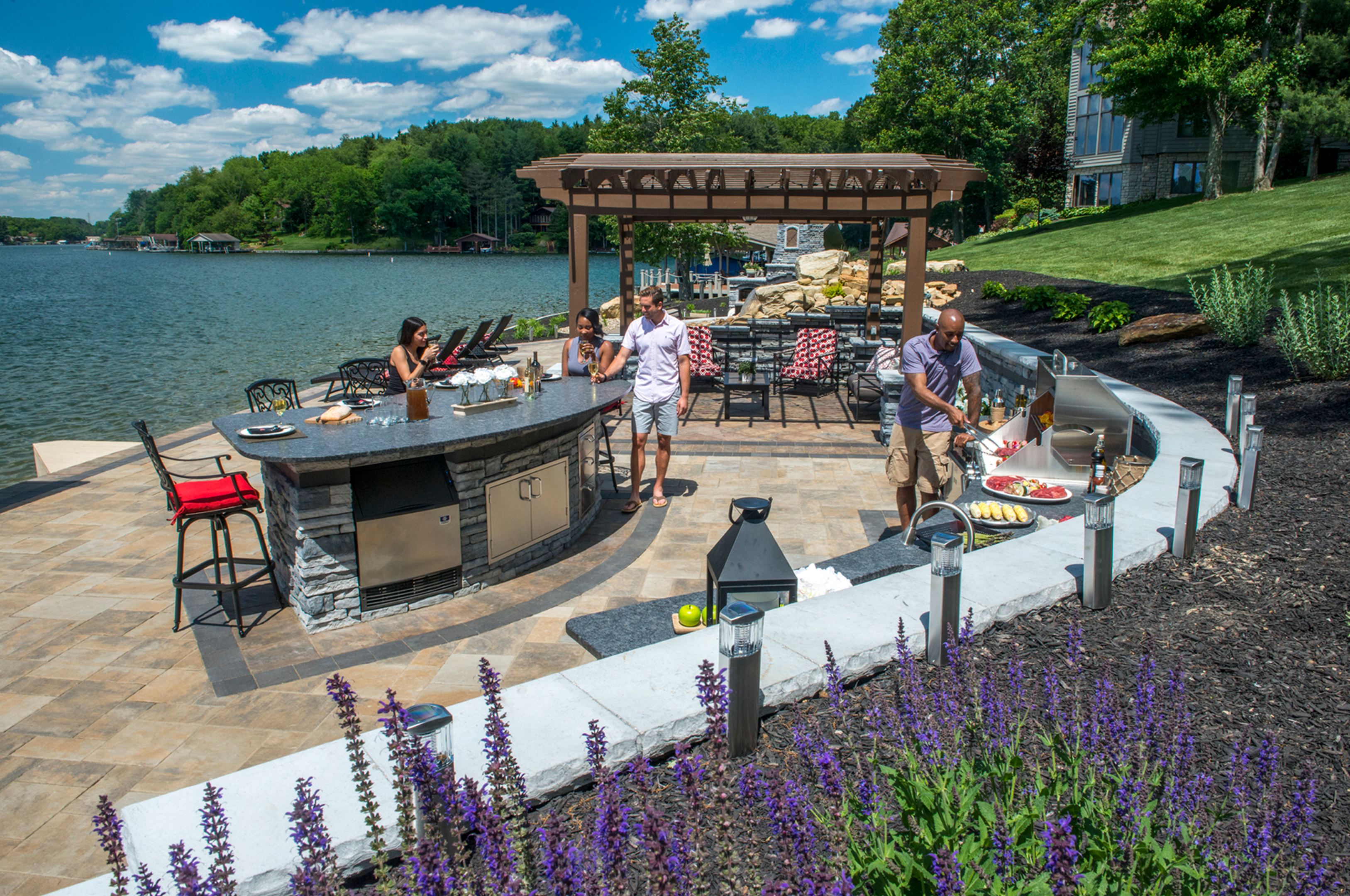 Outdoor lakeside kitchen with people enjoying