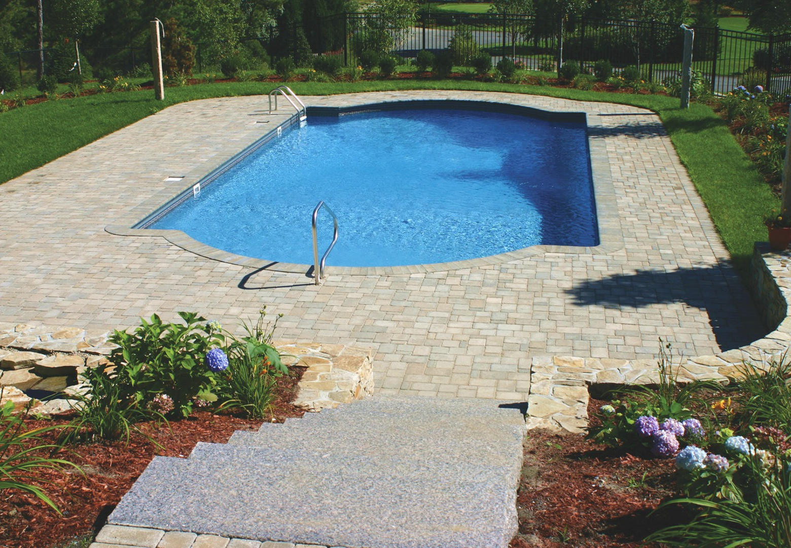 Backyard pool with stone patio
