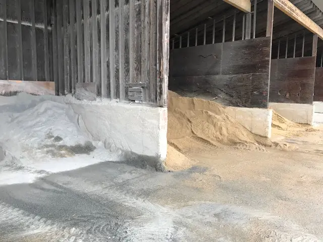 Barn interior with salt and sand piles.