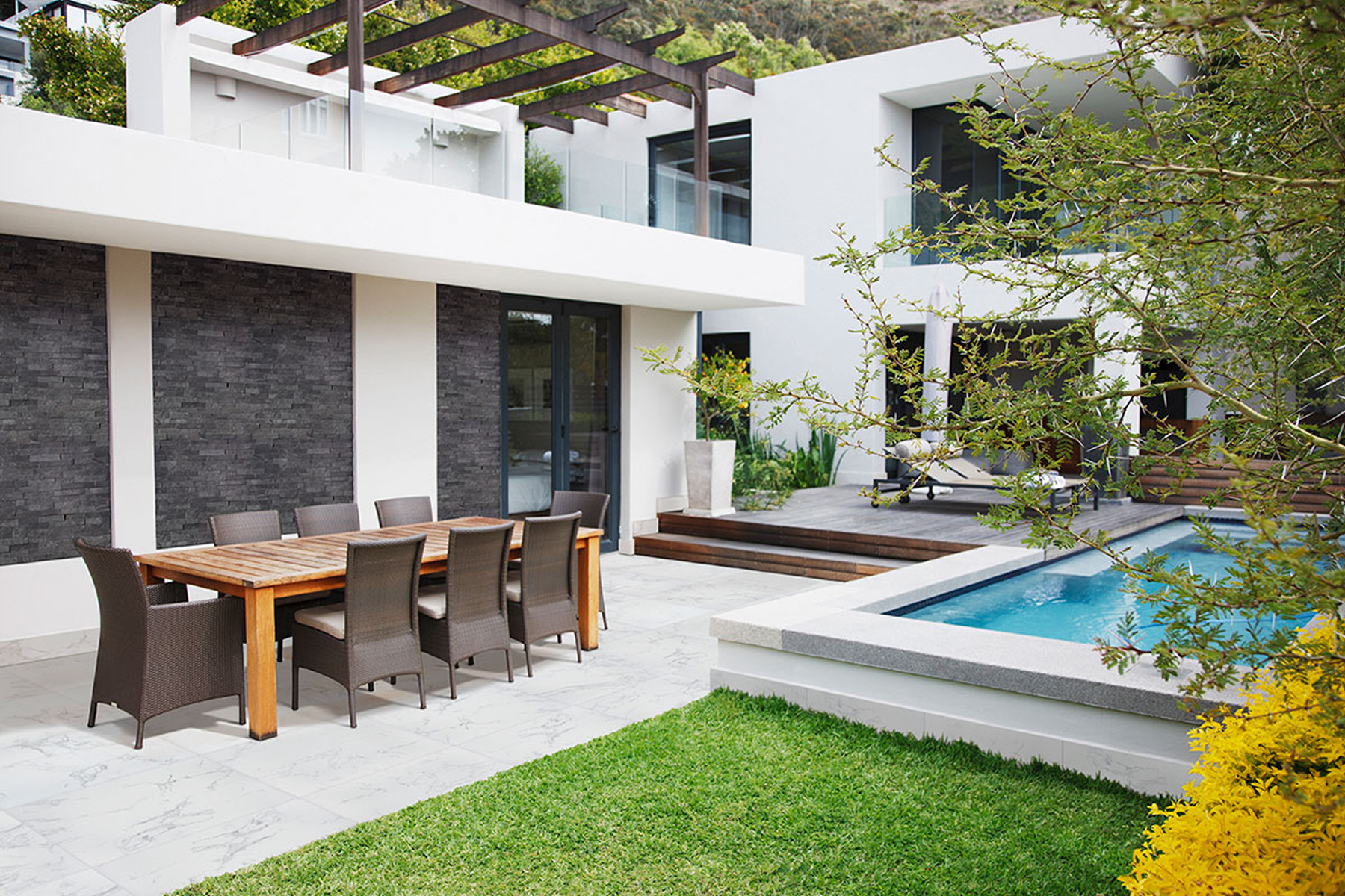 Outdoor dining area beside a swimming pool