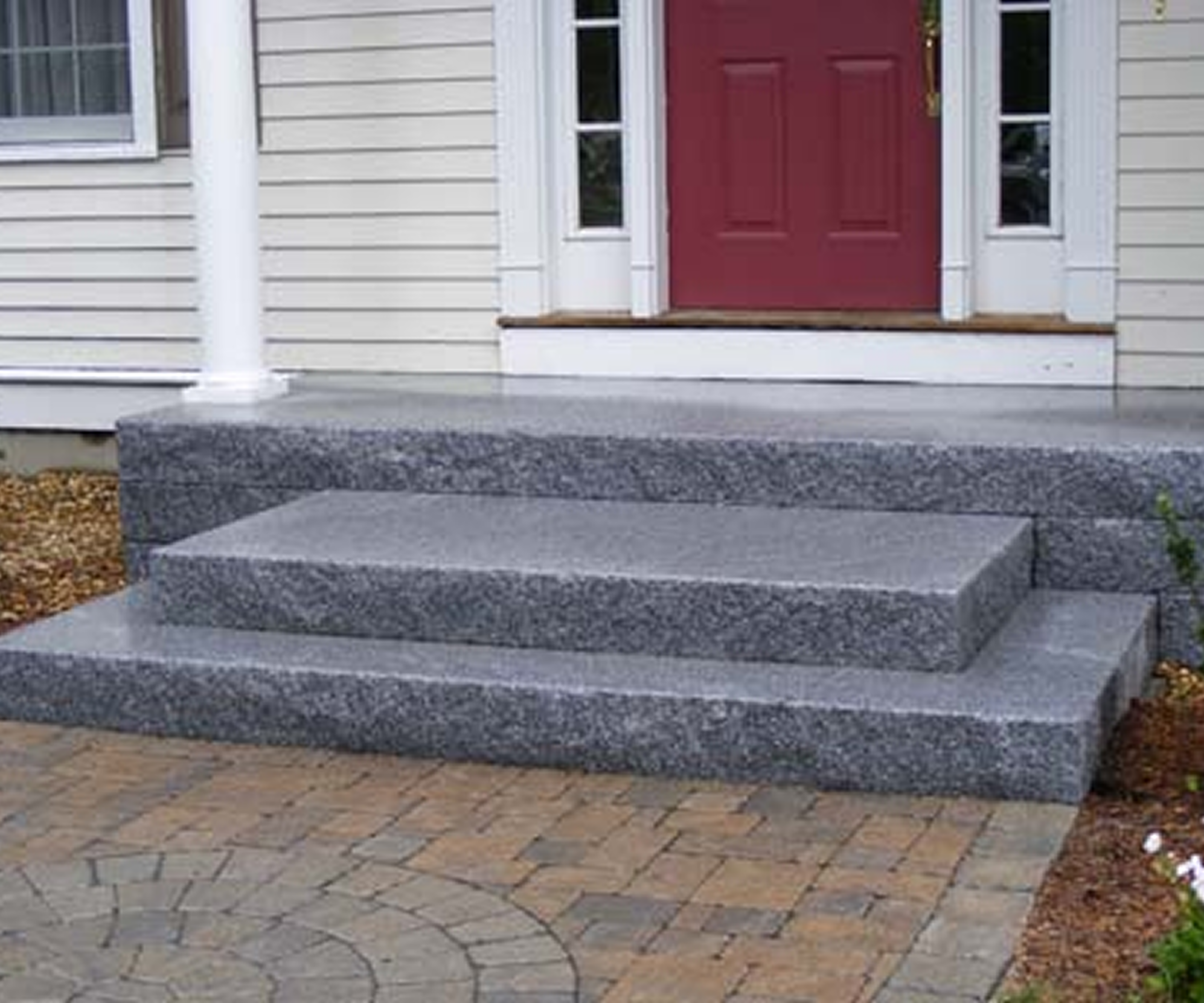 Granite steps leading to red front door.