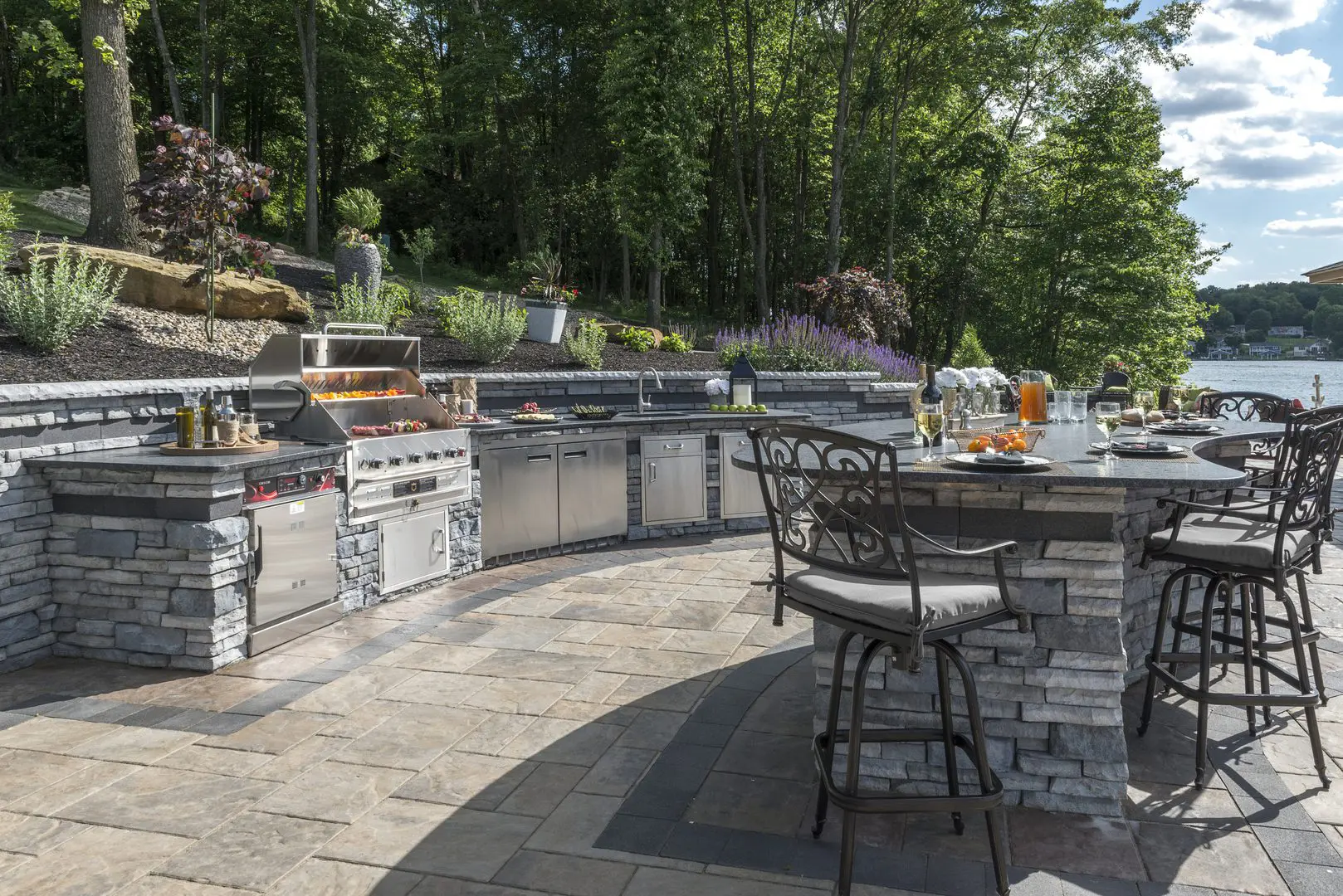 Lakeside outdoor stone kitchen with bar seating