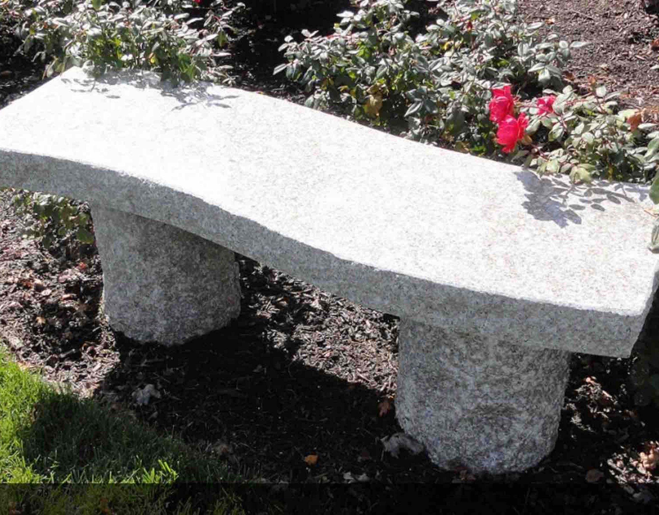 Curved stone bench near flowers