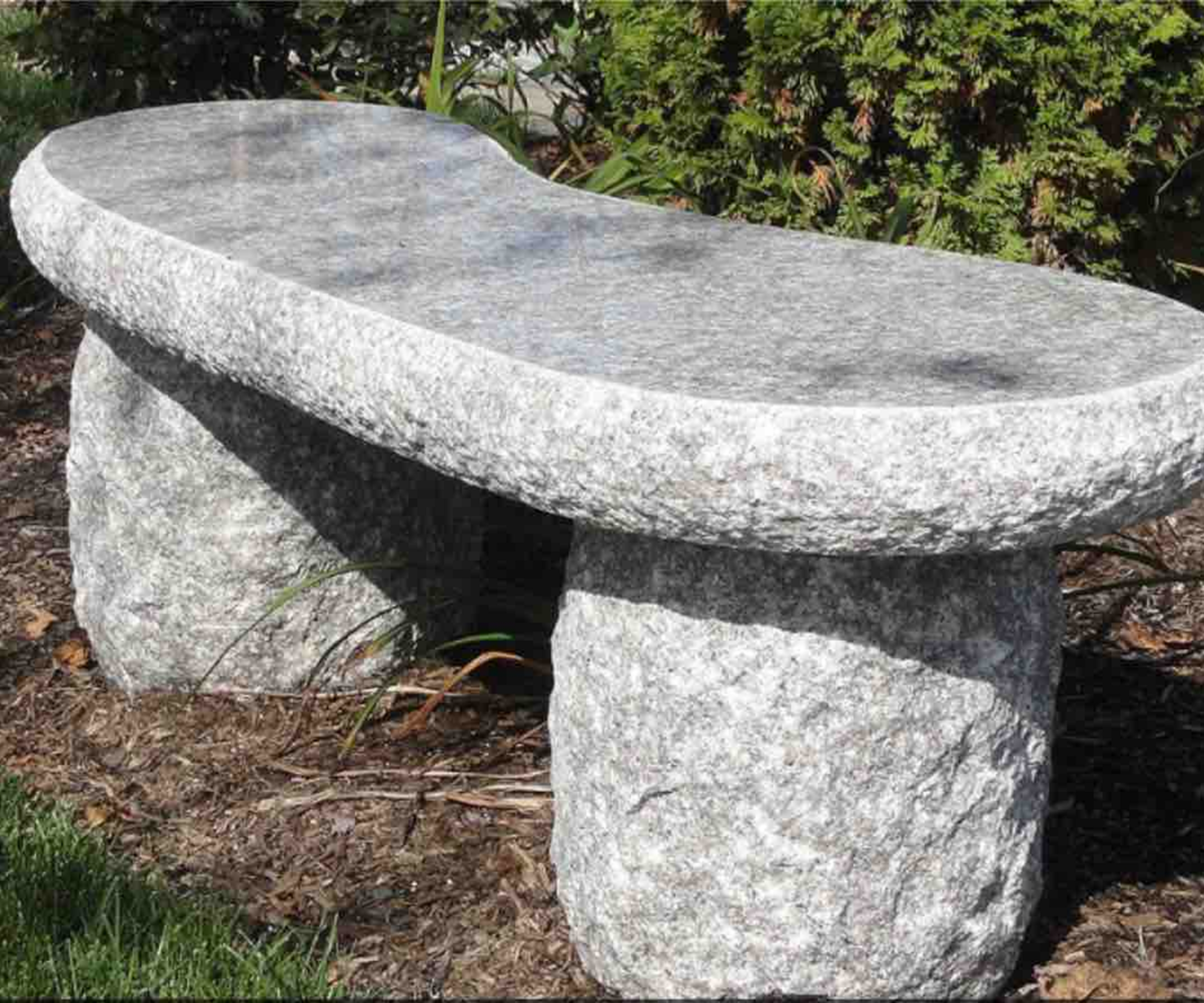 Rustic stone bench on grass
