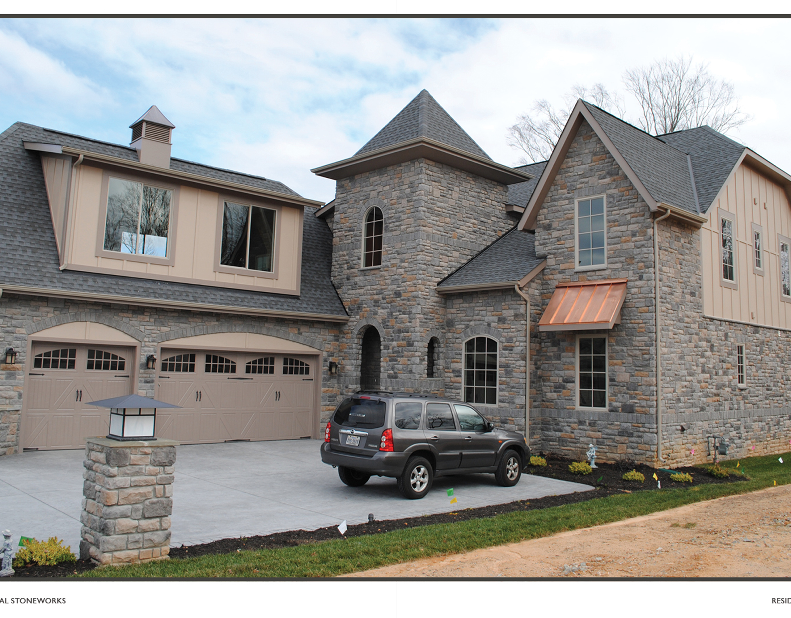 SUV parked in driveway of stone house
