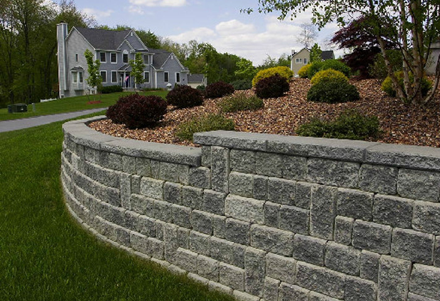 Suburban home with stone wall and garden