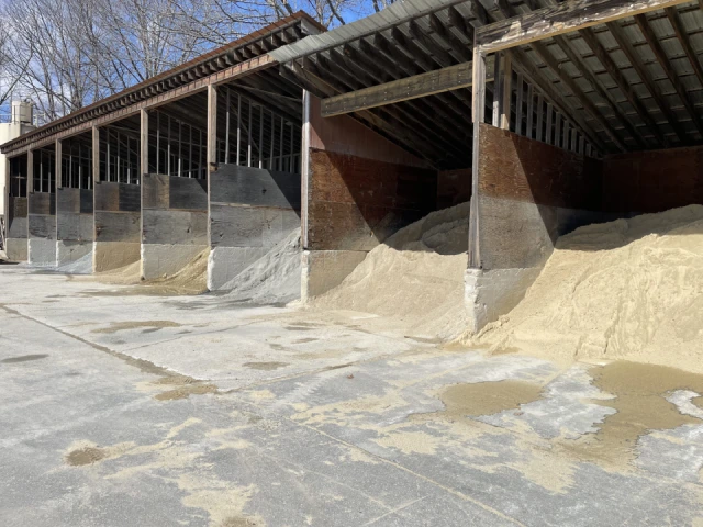 Sand and gravel stored in outdoor bays.