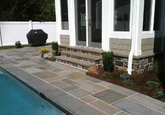 Patio with stone tiles and poolside
